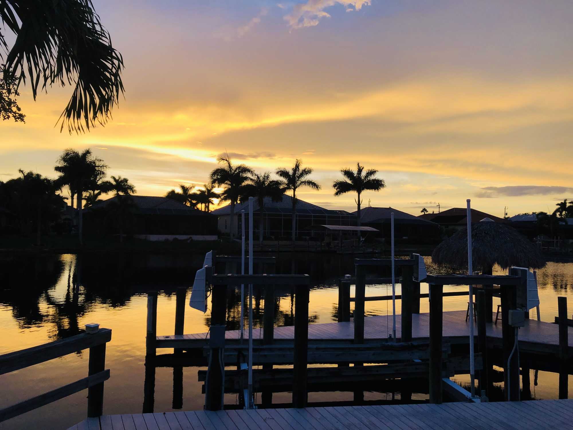 Sun rays through clouds at the end of day over a Cape Coral canal
